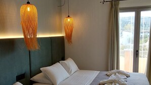 A hotel room with two beds, a large window with curtains, and two hanging lamps. - Ninos on the Beach (Corfu)