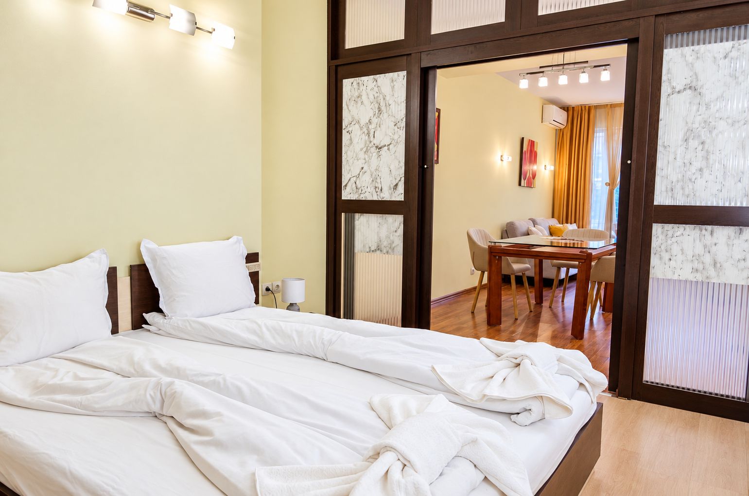 Habitación de hotel con cama, escritorio y zona de comedor con sillas.