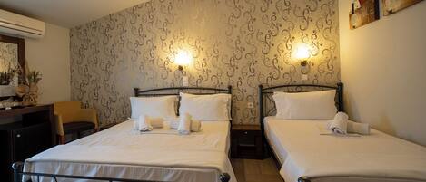 A hotel room with two beds, a desk, and a chair.