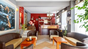 A hotel lobby with a reception desk, seating area, and a large painting on the wall. - Toti Boutique Rooms  (Kalabaka)