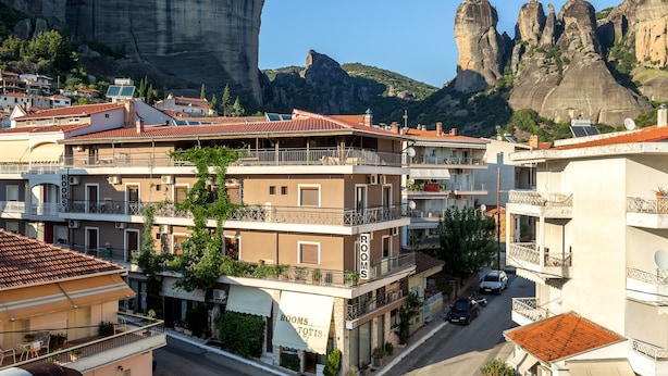 A hotel with multiple floors, balconies, and a view of rocky mountains. - Toti Boutique Rooms  (Kalabaka)