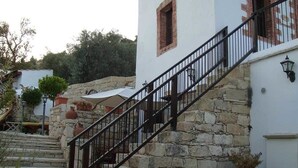 Eine Steintreppe führt zu einem weißen Gebäude mit einem schwarzen Metallgeländer.