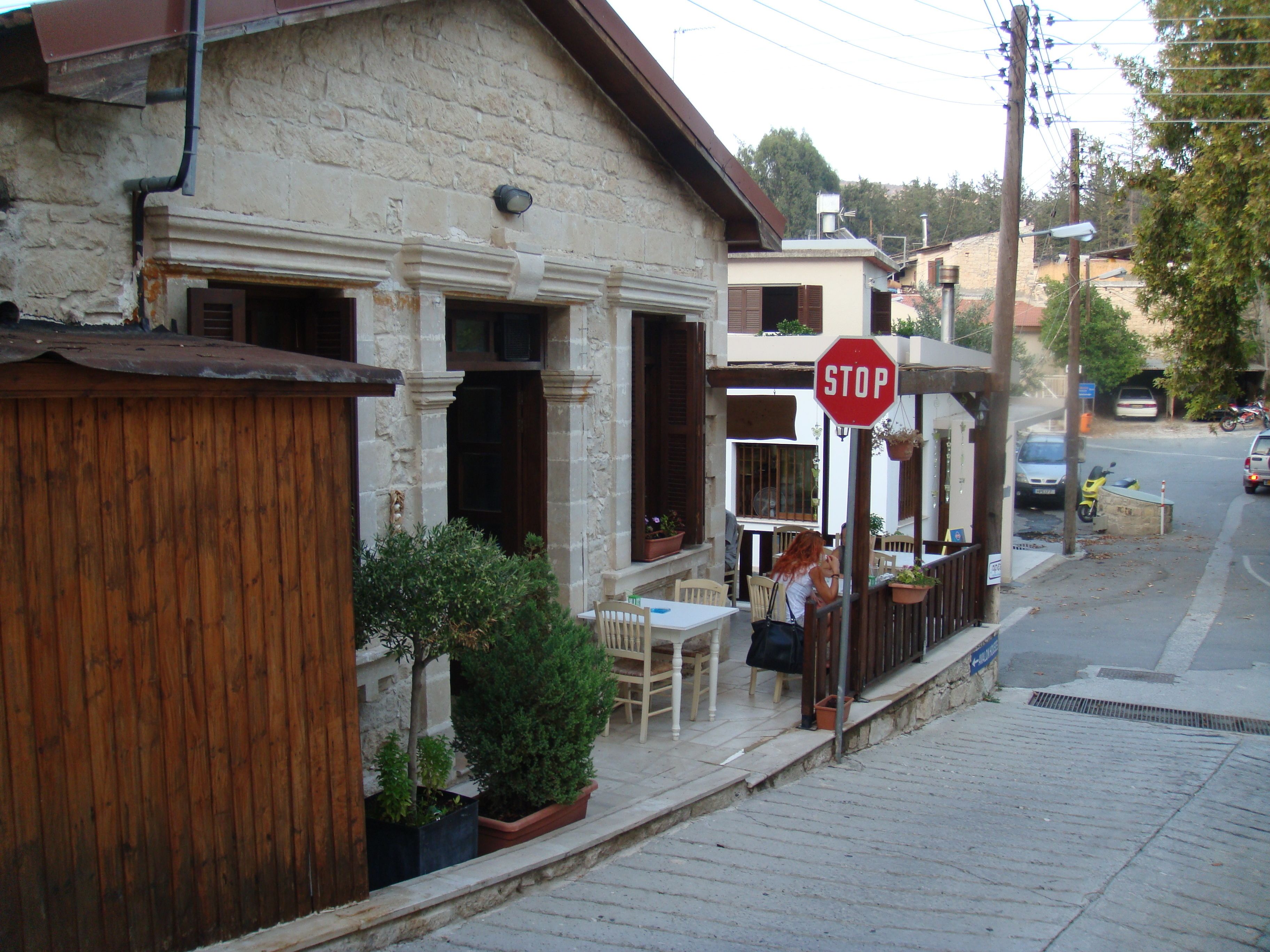 A stone building with a stop sign, outdoor seating, and a small garden.