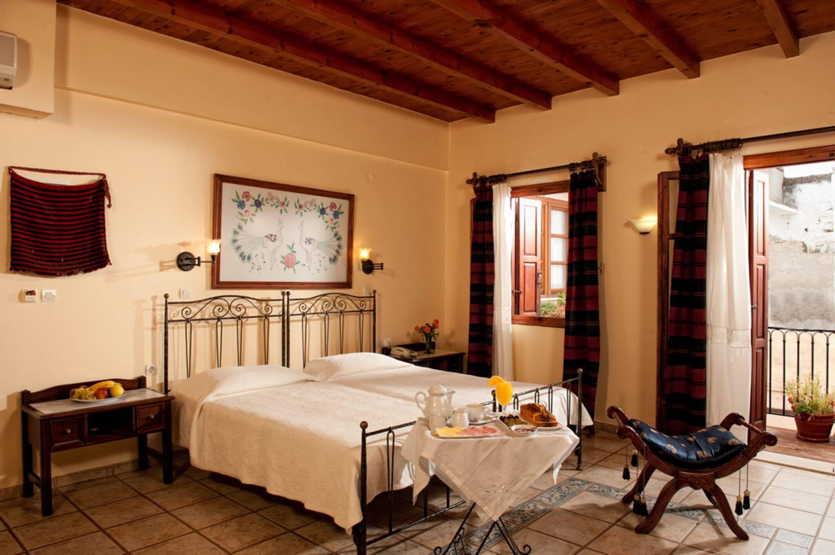 A bedroom with a bed, bedside table, and a small table with breakfast items.