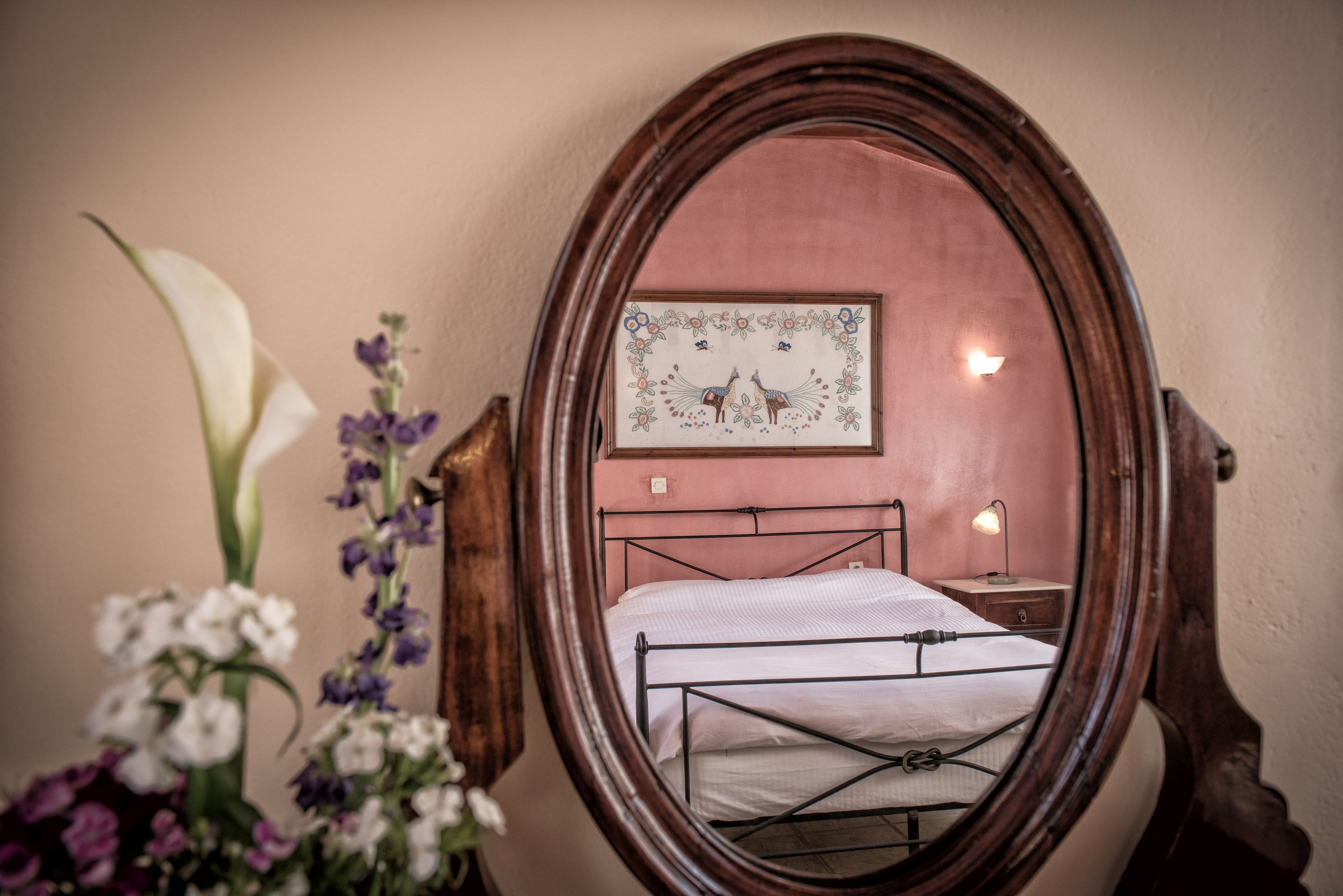 A bedroom with a bed, a bedside table, a lamp, and a framed picture on the wall.
