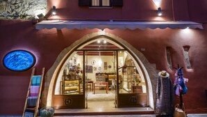Entrada de un hotel boutique con un arco distintivo, un letrero de neón y varios objetos exhibidos en su interior.