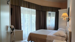 A bedroom with a bed, bedside tables, a lamp, and a window with curtains. - Ausonia (Follonica)