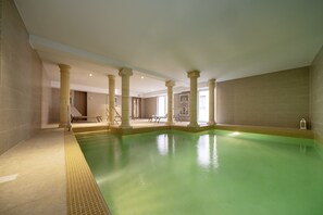 Una piscina techada, sillones reclinables de piscina