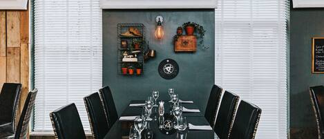 A dining area with a table set for six, surrounded by black chairs.