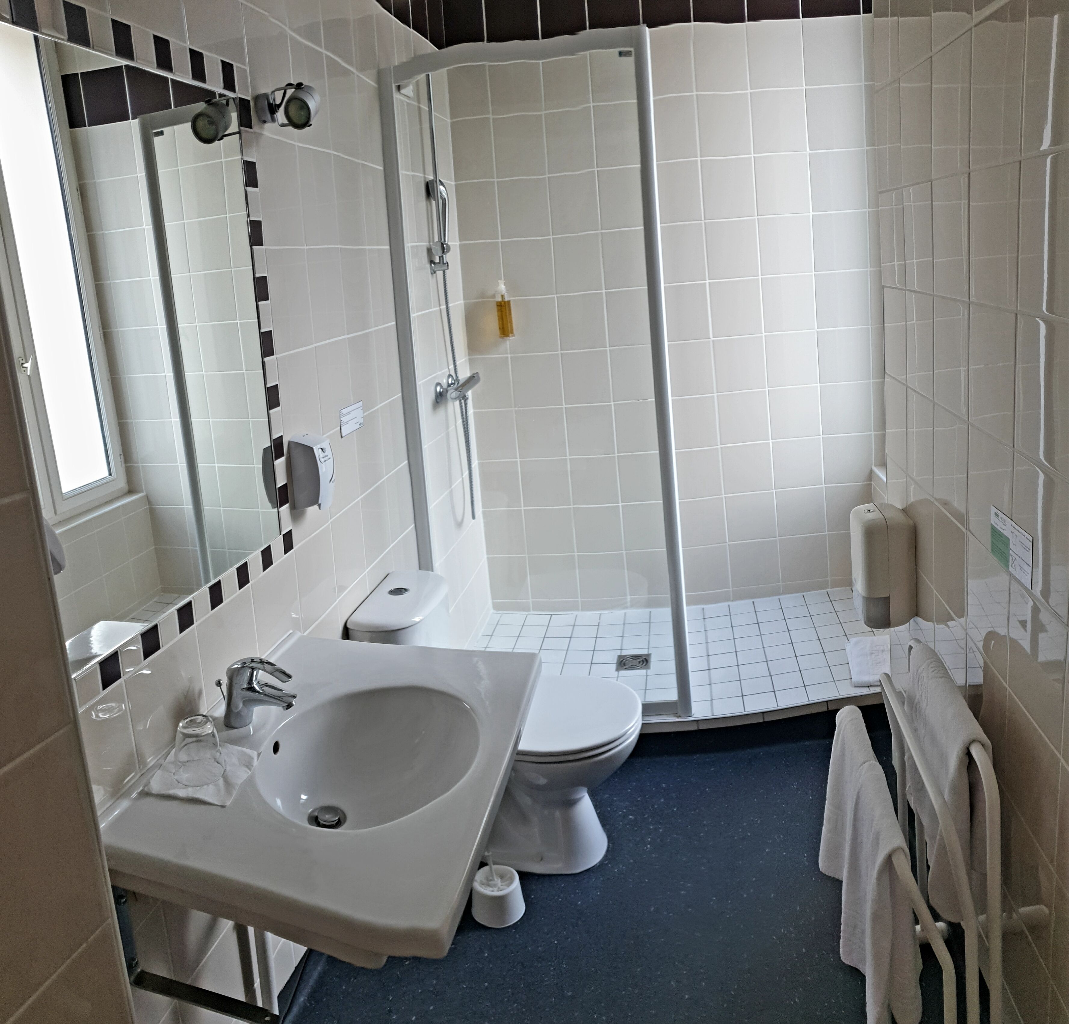 Un baño moderno con lavamanos, inodoro y ducha.