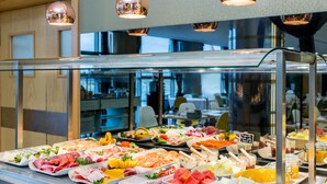 Un bufé con diferentes opciones de comida y una vitrina de vidrio.