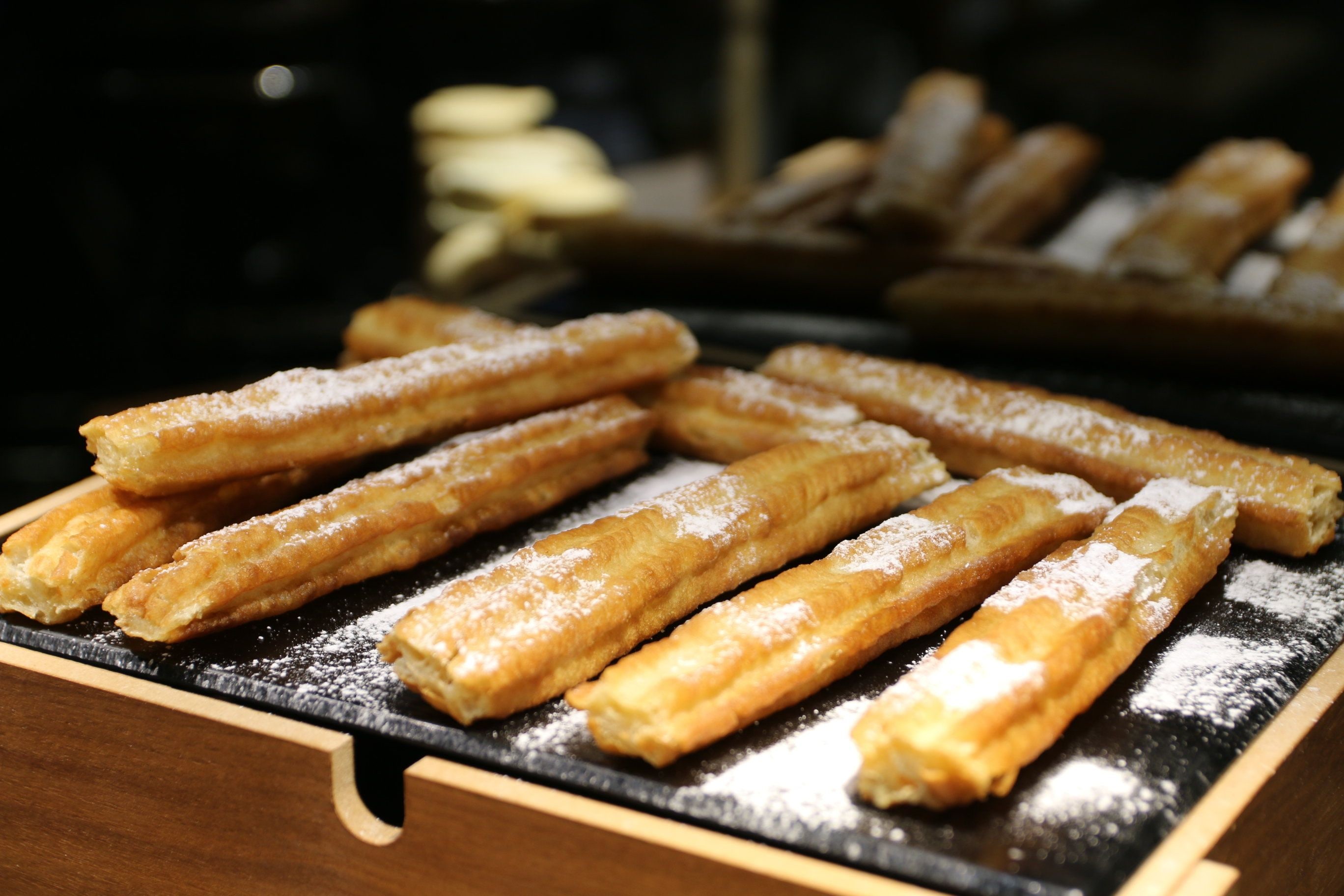A tray of churros dusted with sugar.