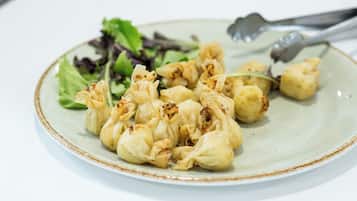 A plate with dumplings and a side salad.