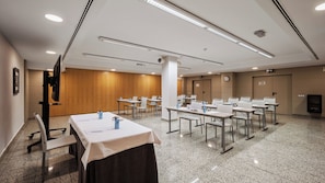A conference room with tables, chairs, and a projector screen. - Crowne Plaza Madrid Airport by IHG (Madrid)