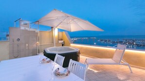 A rooftop terrace with a hot tub, dining table, and chairs, overlooking a marina. - Locanda Alfieri (Termoli)