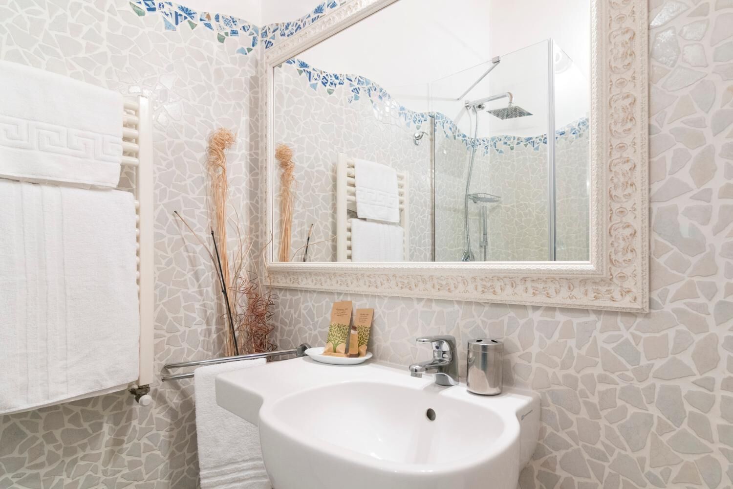 Un baño con lavamanos blanco, un espejo y una ducha.
