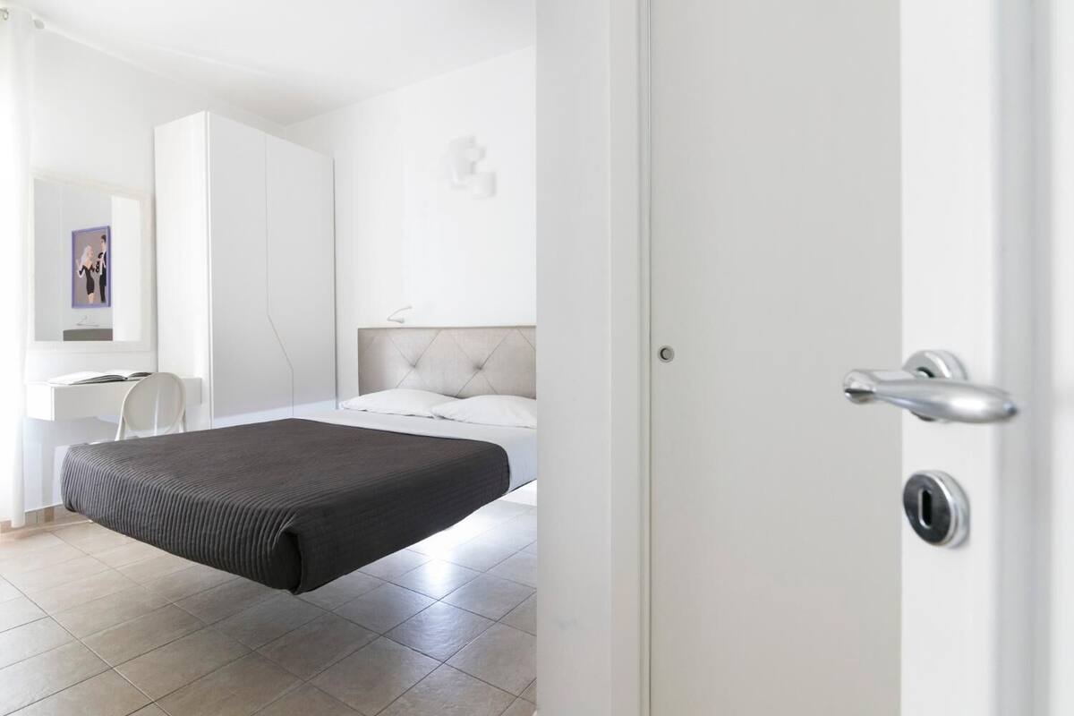 A modern bedroom with a bed, a desk, and a chair.