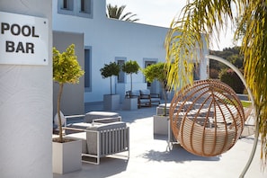 A pool bar area with outdoor seating and a spherical hanging chair. - VOI Marsa Siclà Essentia (Scicli)
