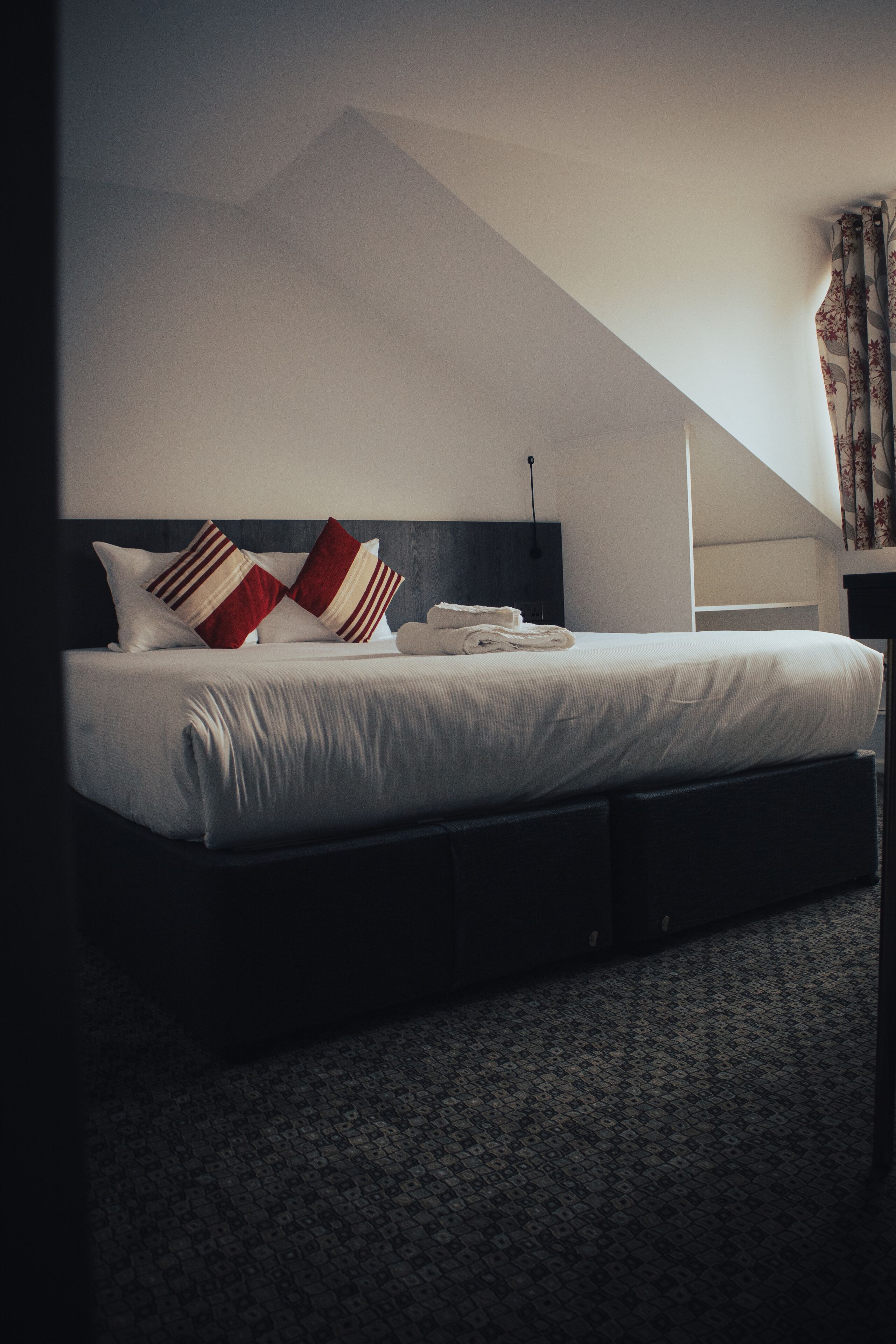 Ein modernes Schlafzimmer mit einem Bett, Kissen und einem ordentlich bezogenen Bett.