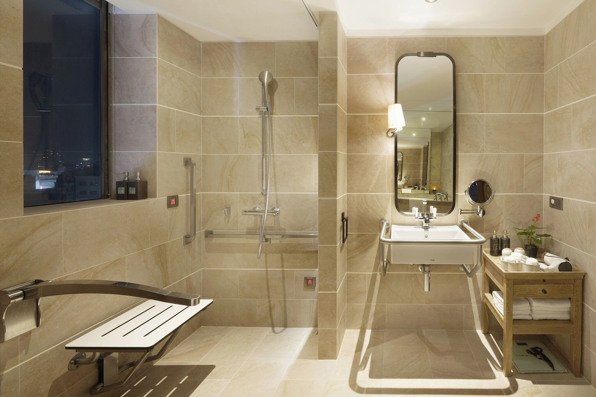 Un baño moderno con cabina de ducha, lavamanos y tocador con espejo.