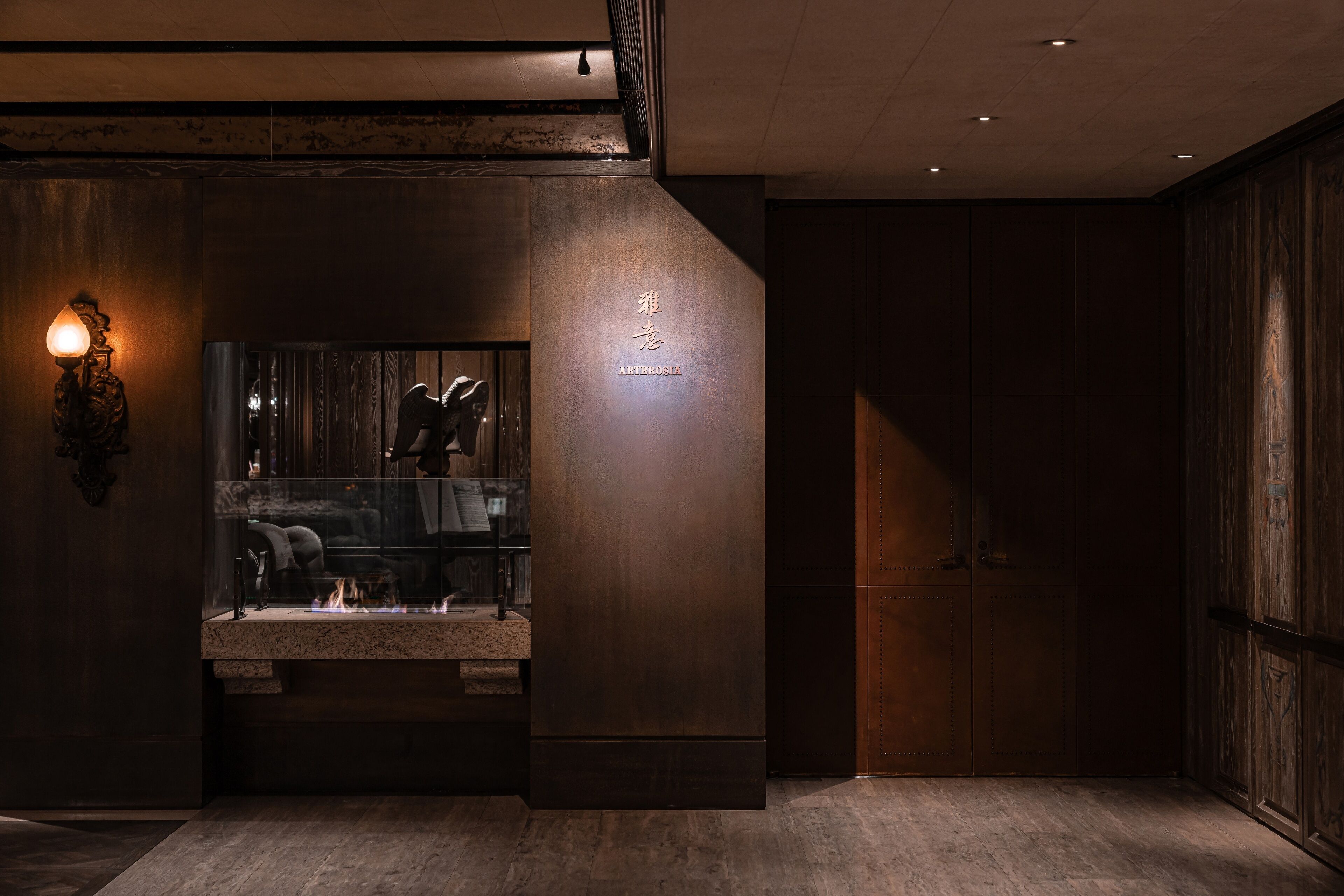 Un intérieur moderne avec des finitions en bois foncé, un plan de travail en pierre avec un évier et un luminaire fixé au mur.