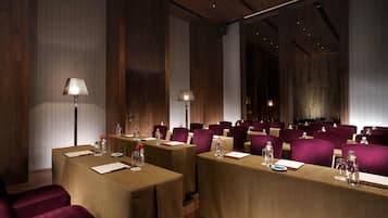 A conference room with tables set for meetings, equipped with water bottles and notepads.