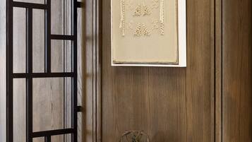 A wooden wall with a framed picture and a small table with a decorative item.