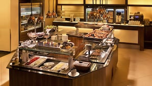 Una mesa de buffet con distintos alimentos y salsas.