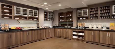 Una cocina amplia con armarios de madera, una isla central y diversos electrodomésticos.
