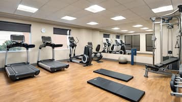 A gym with treadmills, elliptical machines, and free weights.