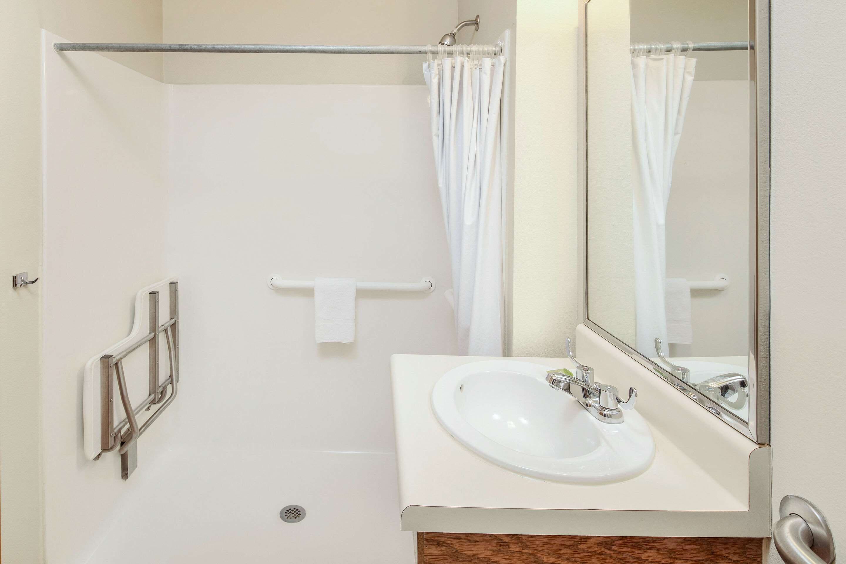 A bathroom with a white sink, a mirror, and a shower curtain.