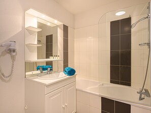 Enjoy a spa-like experience in this serene bathroom with a large bathtub and glass-enclosed shower.
