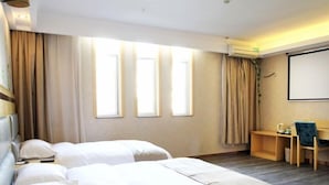 A hotel room with two beds, a desk, and a projector screen. - GreenTree Inn Wuxi ChongAn Temple Jiefang West Road Hotel (Wuxi)