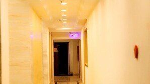 A hallway with a marble floor and walls, leading to a dark room. - GreenTree Inn Wuxi ChongAn Temple Jiefang West Road Hotel (Wuxi)