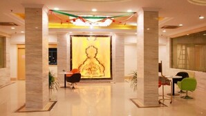 A modern lobby with a large mural, marble columns, and contemporary furniture. - GreenTree Inn Wuxi ChongAn Temple Jiefang West Road Hotel (Wuxi)