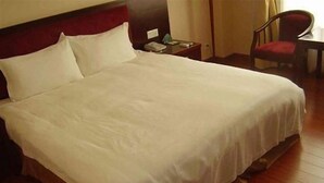 Un llit ben fet amb roba de llit blanca en una habitació d'hotel.