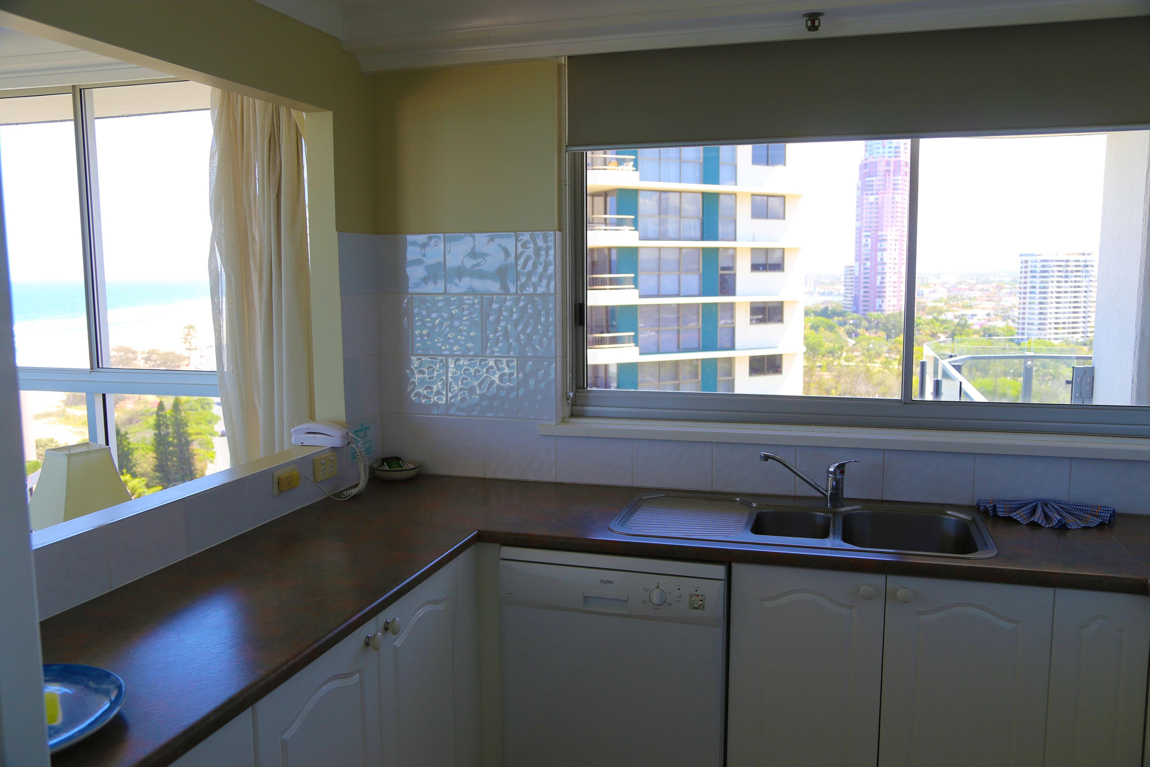 A kitchen with a window, a sink, and a dishwasher.