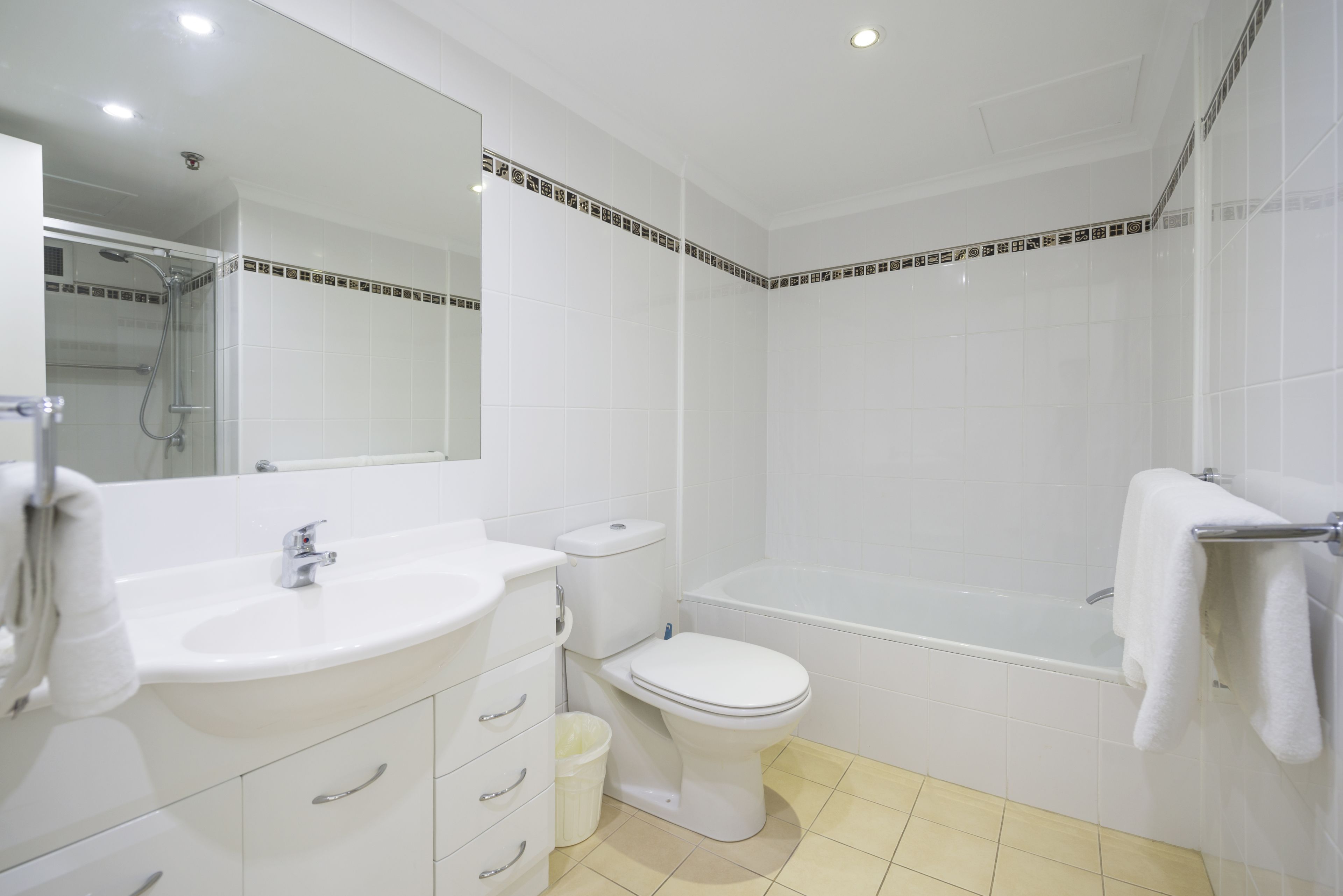 A modern bathroom with a white sink, toilet, and bathtub.