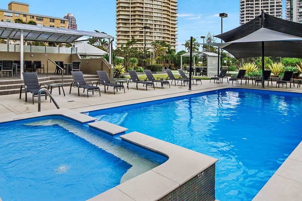 Een binnenzwembad, een buitenzwembad, ligstoelen bij het zwembad