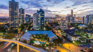 A cityscape at dusk with high-rise buildings, a well-lit intersection, and a prominent dome-shaped structure. - Sunbird Beach Resort (Main Beach)