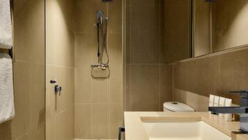 A modern bathroom with a shower, toilet, and sink.