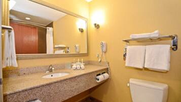 A bathroom with a sink, mirror, towel rack, and toilet.