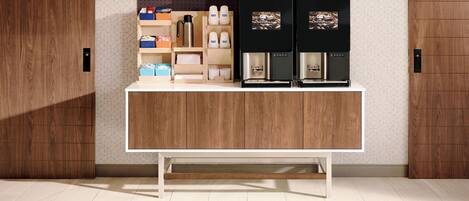 A modern kitchen with a wooden countertop, coffee machines, and storage cabinets.