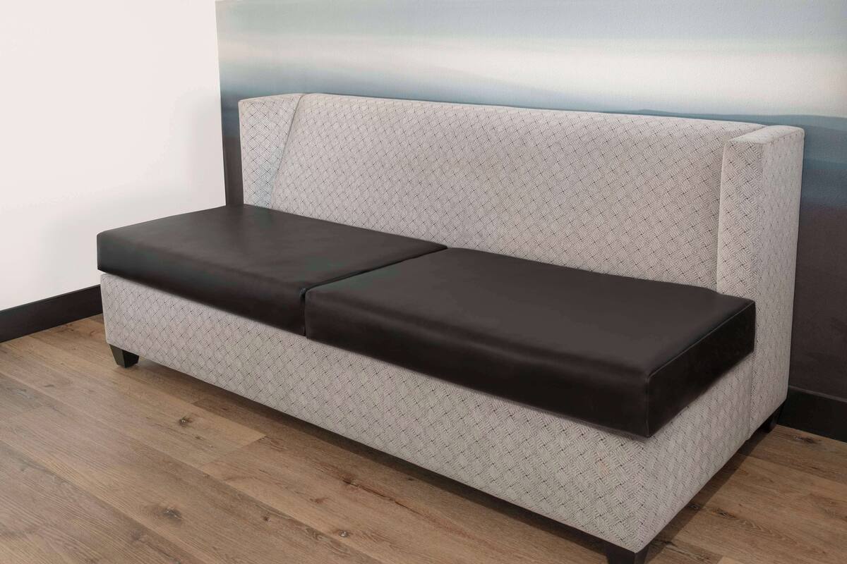 A sofa with a patterned fabric and a dark cushion.