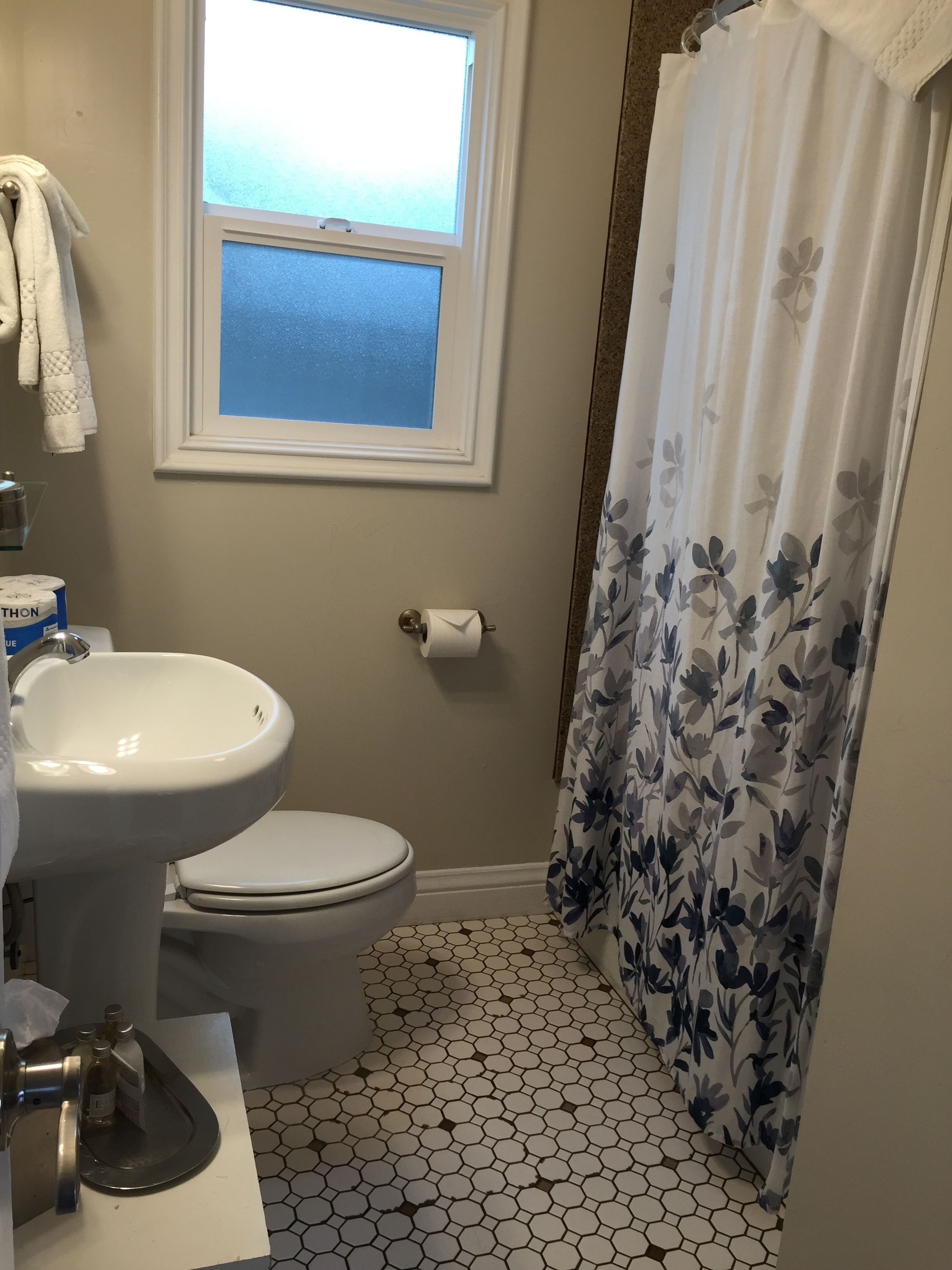 Ein Badezimmer mit Toilette, Waschbecken und Fenster.