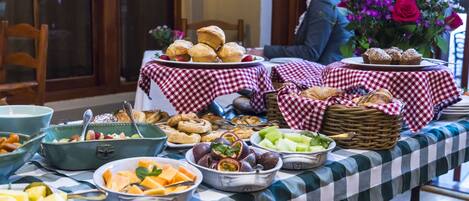 A buffet table with various food items and a checkered tablecloth.