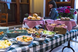 Une table de buffet garnie de divers plats et recouverte d’une nappe à carreaux.