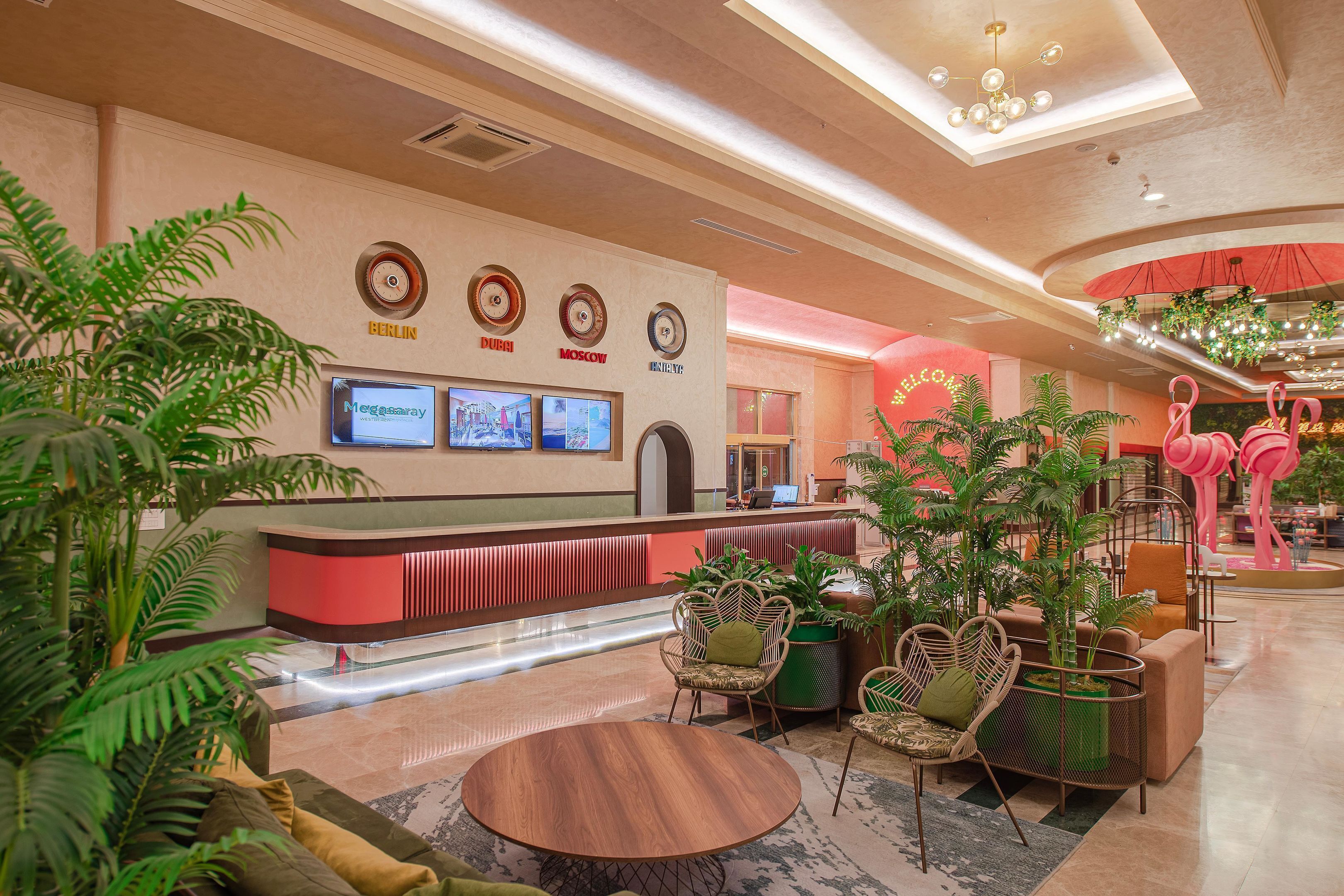 Una hall con reception, area salotto e piante ornamentali.
