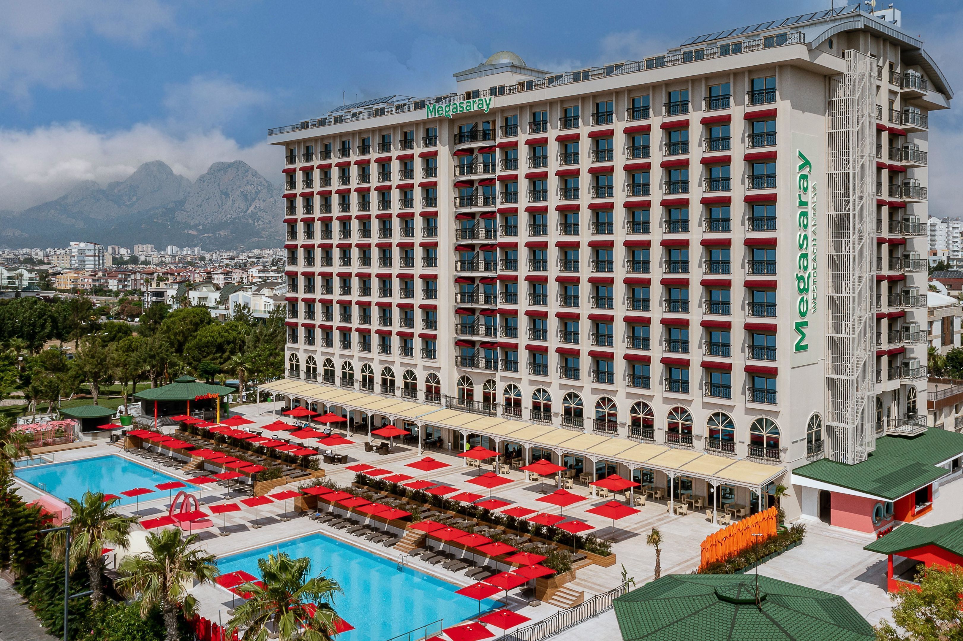 Un grand hôtel avec de nombreux étages, une piscine et des espaces de détente en plein air.
