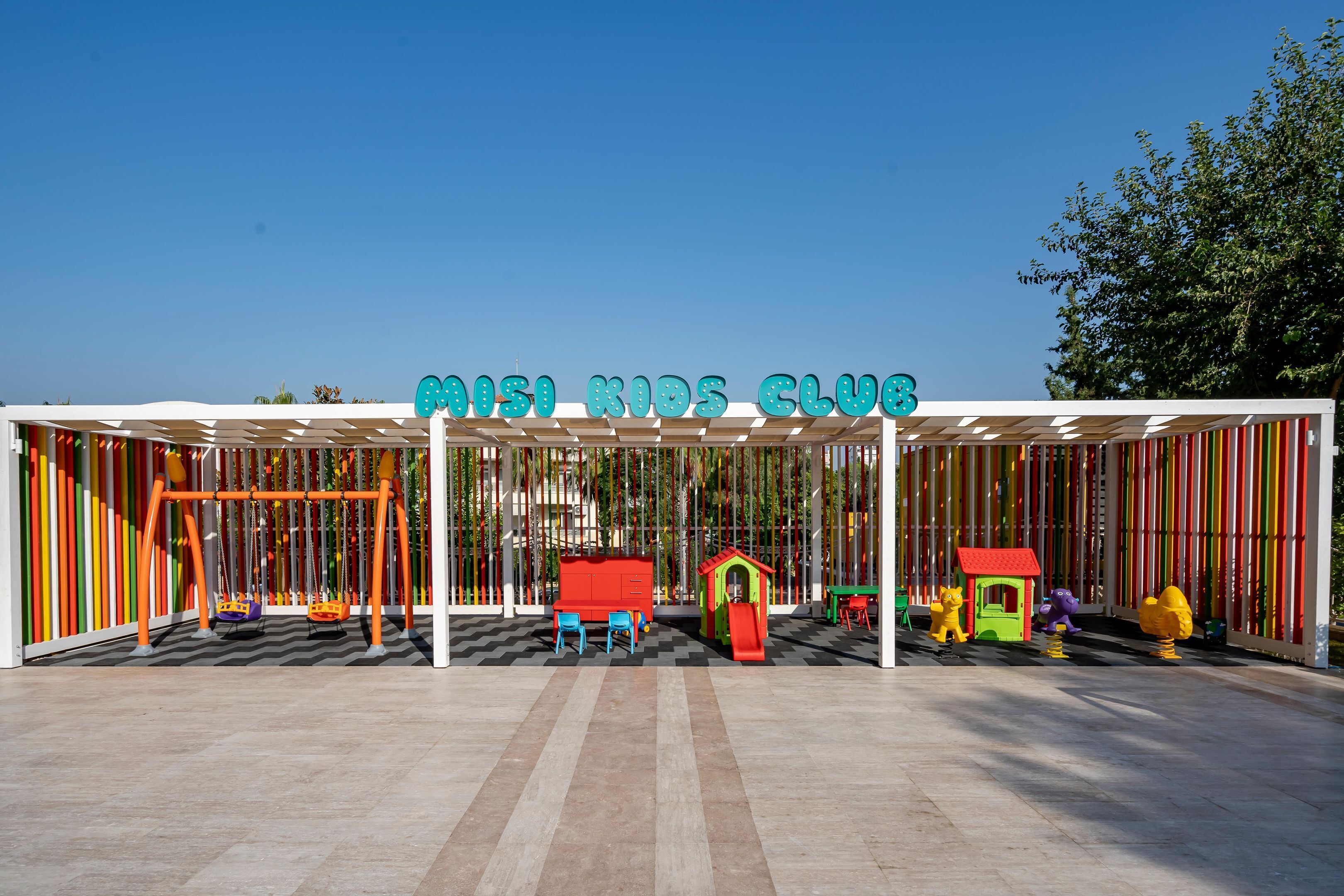 A children's play area with swings, slides, and colorful play structures.
